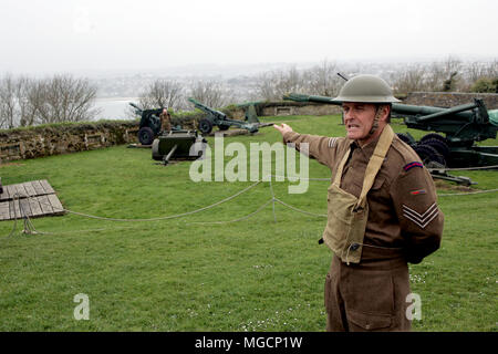 Falmouth, Cornwall, UK - 12 Avril 2018 : l'historien militaire habillé en WW2 sergent d'Artillerie royale uniforme, expliquant sur les pièces d'artillerie abou Banque D'Images