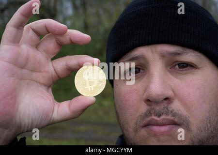 Bitcoin fou amoureux avec une pièce d'or dans votre main , drôle miner avec BTC près du visage Banque D'Images