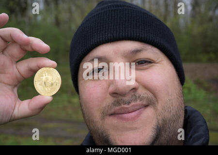 Bitcoin fou amoureux avec une pièce d'or dans votre main , drôle miner avec BTC près du visage Banque D'Images