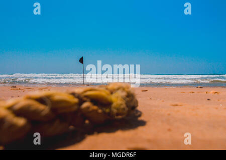 Un indicateur d'alerte noire marquant la limite de la zone de baignade sécuritaire lors d'une belle plage avec ciel bleu et une mer turquoise en Israël. Banque D'Images