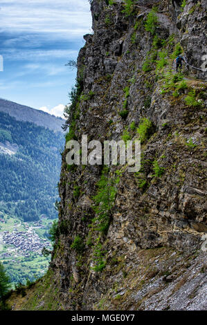 Un homme monte un vtt sur un chemin raide sur le bord d'une falaise près de la ville de Loèche-les-Bains en Valais, Suisse. Banque D'Images