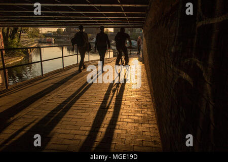 Un cycliste et les marcheurs sur le chemin de halage du Regents Canal au coucher du soleil un soir d'été Banque D'Images