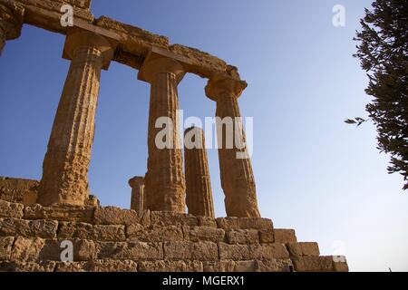 Les ruines d'un temple grec avec les colonnes toujours érigé au coucher du soleil dans la Vallée des Temples (Valle dei Templi) à Agrigente en Sicile Banque D'Images
