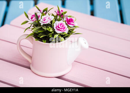 Fleurs artificielles en pots décoratifs bleu sur fond de bois Banque D'Images