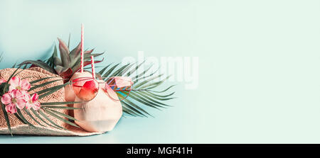 Des vacances d'été . Accessoires de plage : chapeau de paille avec des feuilles de palmiers et de fleurs, rose lunettes de soleil et Cocktail de coco bleu sur fond bleu turquoise, fron Banque D'Images