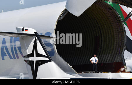 28 avril 2018, l'Allemagne, Schönefeld : un homme debout dans la soute d'un Airbus "Beluga" au salon ILA 2018. Dans l'arrière-plan est un Boeing 747-8 de Lufthansa. Environ 200 appareils sont présentés au cours de l'AID 2018 exposition aéronautique internationale. Les organisateurs attendent environ 150 000 visiteurs. L'ILA a lieu entre 25 et 29 avril 2018. Photo : Ralf Hirschberger/dpa Banque D'Images