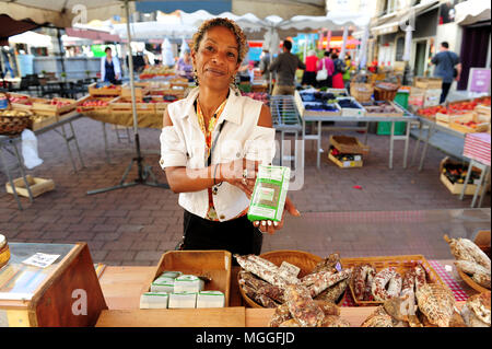 Un vendeur montre un sac de lentilles vertes du Puy au marché des fruits et légumes locaux dans la ville de Puy-en-Velay, France Banque D'Images