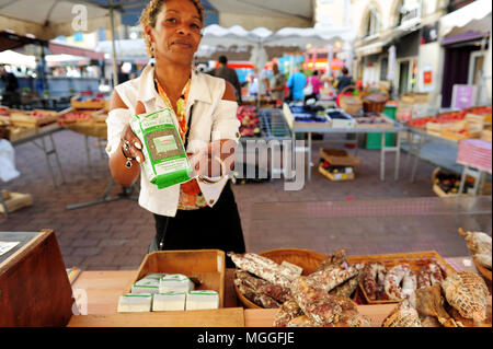 Un vendeur montre un sac de lentilles vertes du Puy au marché des fruits et légumes locaux dans la ville de Puy-en-Velay, France Banque D'Images