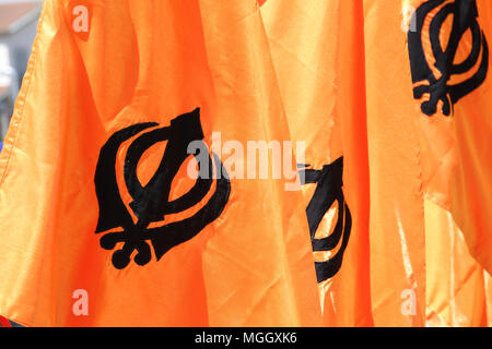 Symbole de la religion Sikh appelé KHANDA constitué par deux cimeterres sur fond orange Banque D'Images