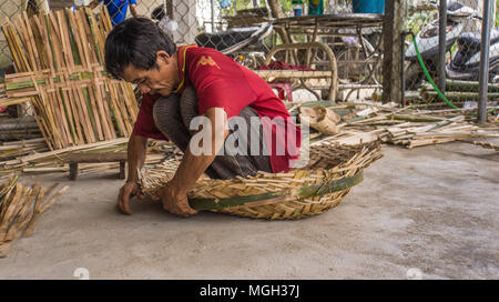 L'homme vietnamiens faisant un panier de bambou tissé ronde Banque D'Images
