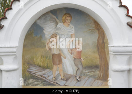 Ange gardien pour aider les enfants à traverser le pont sur le ruisseau. Peinture murale dans la chapelle funéraire au cimetière du village à l'Acul du Nord Département du Nord nad Vltavou en Bohême du Sud, en République tchèque. Chapelles funéraires placés sur le mur du cimetière étaient décorées de peintures murales dans les années 1840 par le peintre local František Mikule menée avec curé Vít Cíza, qui a également composé des poèmes pour chaque fresque. Les peintures murales ont été repeintes à plusieurs reprises au cours des xixe et xxe siècles et entièrement restaurée par l'équipe dirigée par Jitka Musilová en 2010-2013. Banque D'Images