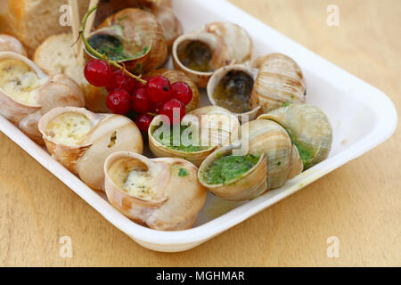 Close up street fast food à emporter, partie de l'escargot les escargots cuisinés avec les fines herbes et l'ail beurre et pain baguette, high angle view Banque D'Images