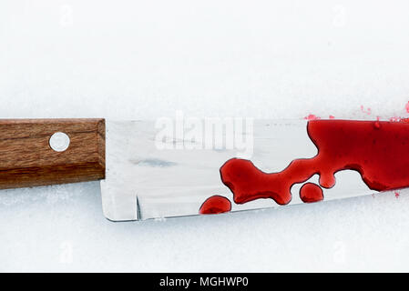 Couteau de cuisine en métal pointu utilisé comme arme du crime violent avec du sang tombe sur un fond blanc de la neige. Blade couverts dans la violence with copy space Banque D'Images
