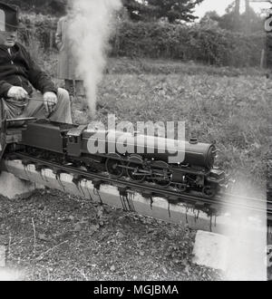 Années 1950, historiques, amteur mâles adultes amateurs de chemin de fer avec un train à vapeur sur un chemin de fer miniature, England, UK. Banque D'Images