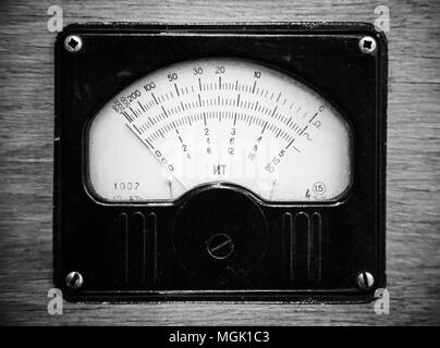 Close-up photo monochrome électrique vintage de voltmètre en panneau de bois. Banque D'Images