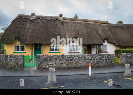 Cottage au toit de chaume traditionnel, village d'Adare, l'Irlande, bâtiment coloré, ciel couvert, le printemps Banque D'Images