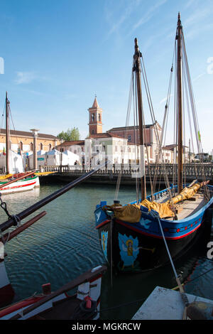 Vue sur Porto Canale, le canal central dans la belle ville de Cesenatico, sur la côte Adriatique en Italie. Bateau peint historique dans l'avant-plan Banque D'Images