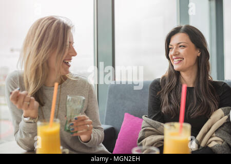 Portrait de deux jeunes belles femmes du coffee shop, girl talk. Deux amis féminins bénéficiant ensemble dans un restaurant de rire, parler et le commérage. Banque D'Images