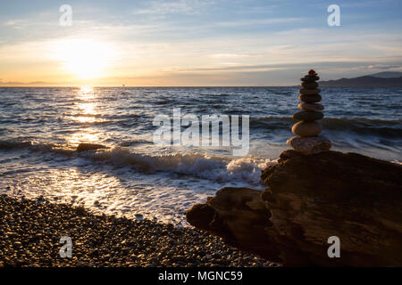 Pile de rochers entassés à l'océan lors d'un coucher de soleil. Pris dans Wreck Beach, Vancouver, Colombie-Britannique, Canada. Banque D'Images