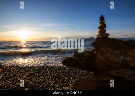 Pile de rochers entassés à l'océan lors d'un coucher de soleil. Pris dans Wreck Beach, Vancouver, Colombie-Britannique, Canada. Banque D'Images