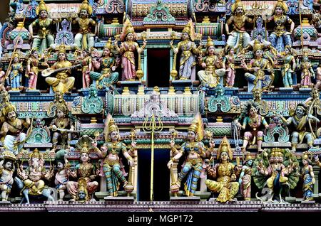 Vue de face d'un groupe de statues de pierre colorés représentant des dieux hindous et des divinités indiennes sur l'extérieur d'un vieux temple dans Little India, Singapour Banque D'Images