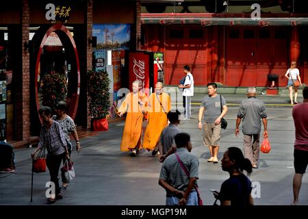 Deux moines bouddhistes en robe safran marchant sur la place à l'extérieur de l'Buddha Tooth Relic Temple dans le quartier historique de Chinatown, à Singapour Banque D'Images