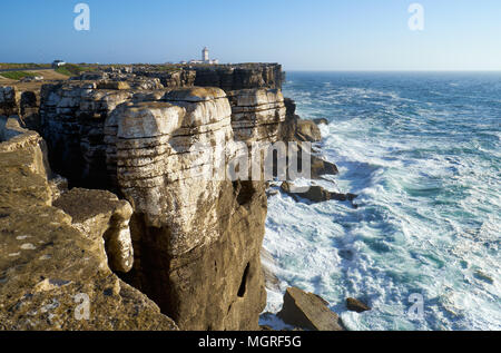 Les rochers et les vagues de surf dans l'océan, près de Cabo Carvoeiro (Cap de charbon), la Péninsule de Peniche avec phare sur arrière-plan, Portugal Banque D'Images