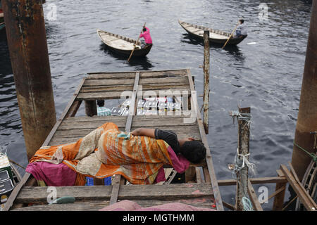 Dhaka, Bangladesh. Apr 28, 2018. Un garçon sans-abri dort sur un pont comme bateliers pour exécuter pour passagers dans la rive de la rivière Buriganga. Credit : Md. Mehedi Hasan/ZUMA/Alamy Fil Live News Banque D'Images