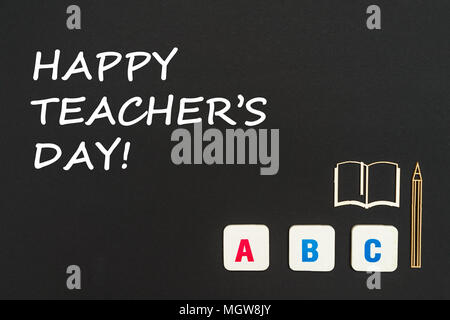 Concept english school, happy teacher's day, abc lettres chipboard, mini-livre, un stylo sur tableau noir Banque D'Images