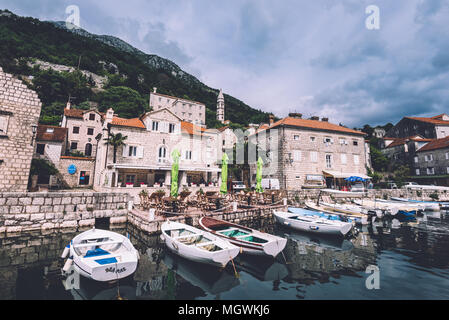 Perast, Monténégro - Juin 3th, 2016. Promenade en bateau de la jetée et de la ville de Perast sur baie de Kotor au Monténégro. Maisons traditionnelles en pierre, montagnes, ciel nuageux Banque D'Images