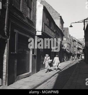 Années 1950, tableau historique de "la pagaille" à York, Angleterre, Royaume-Uni, une ancienne cité médiévale rue pavées étroites bordées d'anciennes en surplomb bâtiments à pans de bois et célèbre pour les boucheries (25 en 1872) qui ont utilisé au commerce le long de celle-ci au 19e siècle. En effet, le mot 'shambles' est un vieux terme pour l'abattoir. Banque D'Images