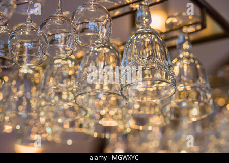 Close up verre de vin sur une grille au-dessus de bar comptoir. Bar de l'intérieur. Verres accrocher sur bar. Verre vide du verre pour vin et champagne dans close-up row.focus sélectif. Banque D'Images