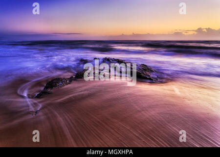 Lever de soleil sur l'horizon coloré de Sandy Shelly beach avec Rocky Stone dans la marée de la mer dans la ville de Nambucca Heads Australian Pacific coast , NSW. Banque D'Images