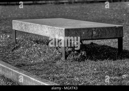 Banc de granit en pierre monochrome en parc public, lieu de détente. Banque D'Images