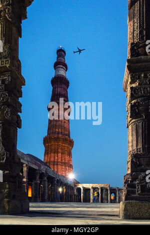 Petit vol d'un avion dans le ciel au cours de l'heure bleue dans le complexe Qûtb Minâr, le patrimoine me demande de New Delhi Banque D'Images