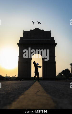 Jonglage football freestyle à la porte de l'Inde au lever du soleil, avec les oiseaux en plein vol à New Delhi Banque D'Images