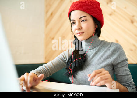 Jeune femme Blogging in Cafe Banque D'Images