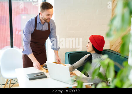 Waiter Serving Young Woman in Cafe Banque D'Images