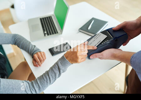 Femme de payer par carte NFC in Cafe Banque D'Images