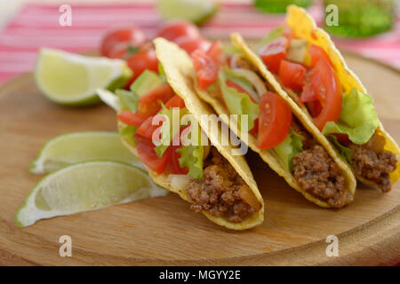 Les tacos avec du boeuf haché et de légumes sur une planche à découper en bois Banque D'Images