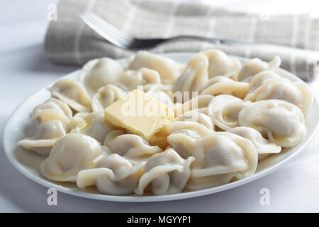 Pelmeni avec du beurre sur un gros plan de la plaque Banque D'Images