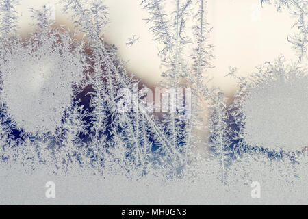 Lever du soleil derrière une fenêtre avec le gel des modèles dans l'hiver Banque D'Images