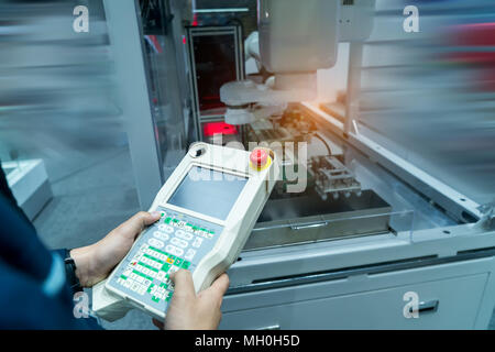 À l'aide d'un comprimé à l'ingénieur de contrôler la machine en temps réel.L'usage de l'usine Smart bras de robot d'automatisation dans l'industrie de la fabrication automobile Banque D'Images