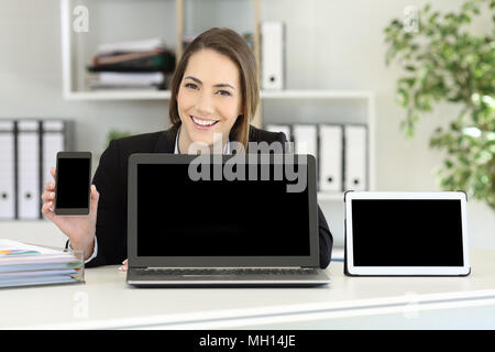 Professionnels office worker montrant différents écrans vierges sur un bureau Banque D'Images