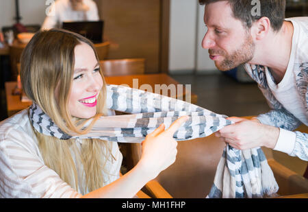 Bel homme drôle sa petite amie en tirant à côté de son foulard - l'amour, romantique, relation concept Banque D'Images