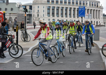 Un Royal Parks guide officiel mène une meute de jeunes touristes sur London Bike Company vélos en direction du sud sur Blackfrairs Bridge dans le centre de Londres du Banque D'Images