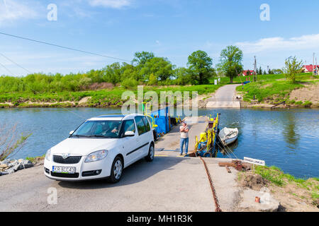 La rivière Vistule, Pologne - Apr 28, 2018 : voiture laissant petit ferry qui transporte des personnes et des véhicules de l'autre côté de la rivière aux beaux jours du printemps. Ce pla Banque D'Images