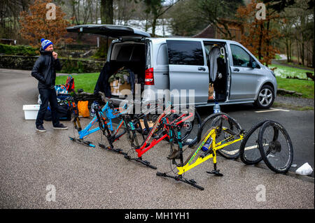 Deux hommes déballage des vtt à une Mercedes Vito van dans un parking à Grizedale dans le Lake District. Banque D'Images