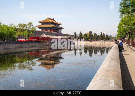 Un groupe d'amis la capture de poissons dans les douves qui entourent la Cité Interdite, Pékin, Chine. Au loin le portail nord et des foules de touristes. Banque D'Images