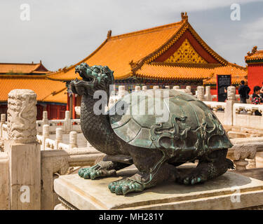 Tortue bronze sculpture à l'extérieur de la salle de l'harmonie suprême, la Cité Interdite. Derrière les balustrades de marbre blanc et jaune des toits vitrés peuvent être vus. Banque D'Images